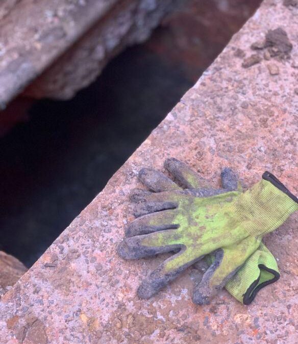 Two gloves in front of a trench in Melbourne for floor relevelling in Melbourne Homes