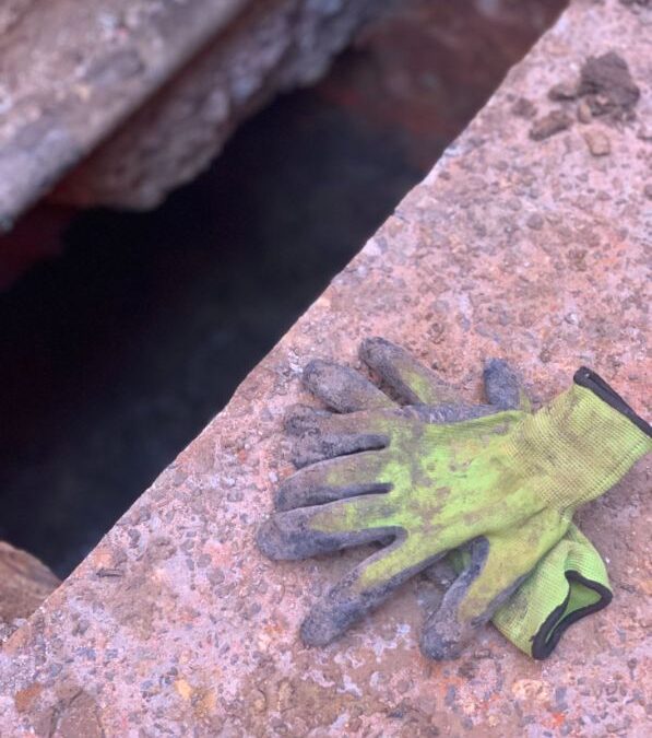 Two gloves in front of a trench used by one of the employee in Underpinning Box Hill Services
